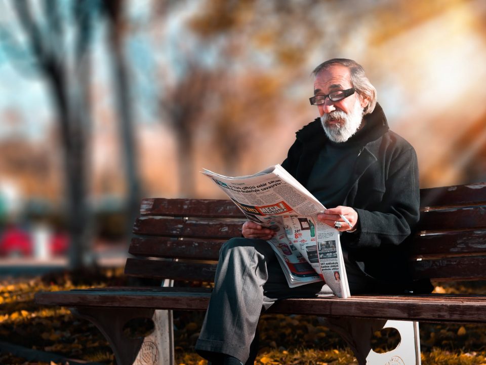 photo of man reading newspaper